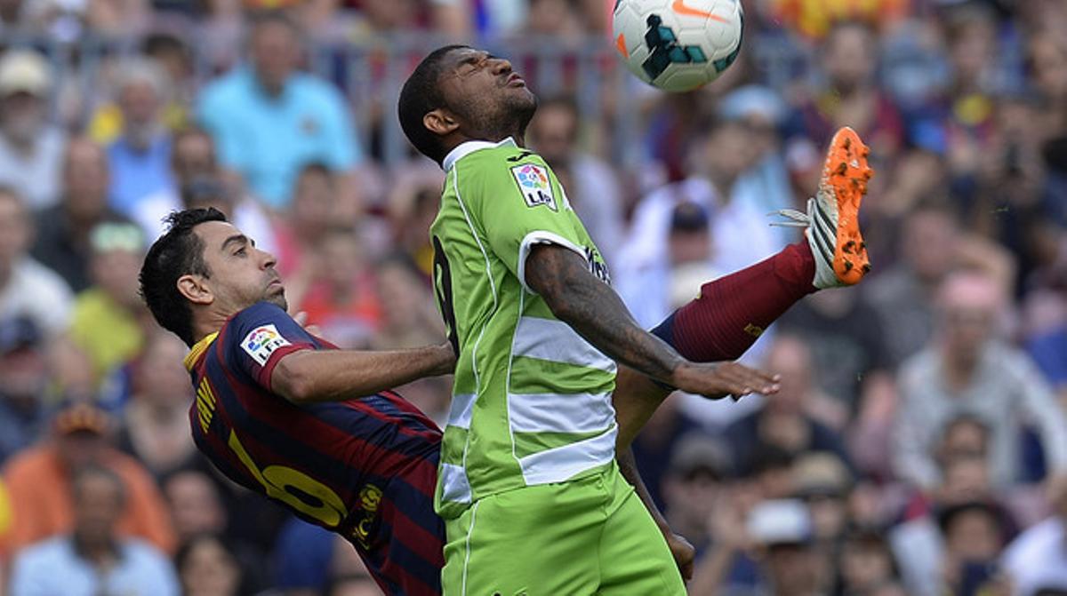 Xavi i Escudero es barallen per una pilota durant el partit que ha enfrontat el Barça i el Getafe al Camp Nou.