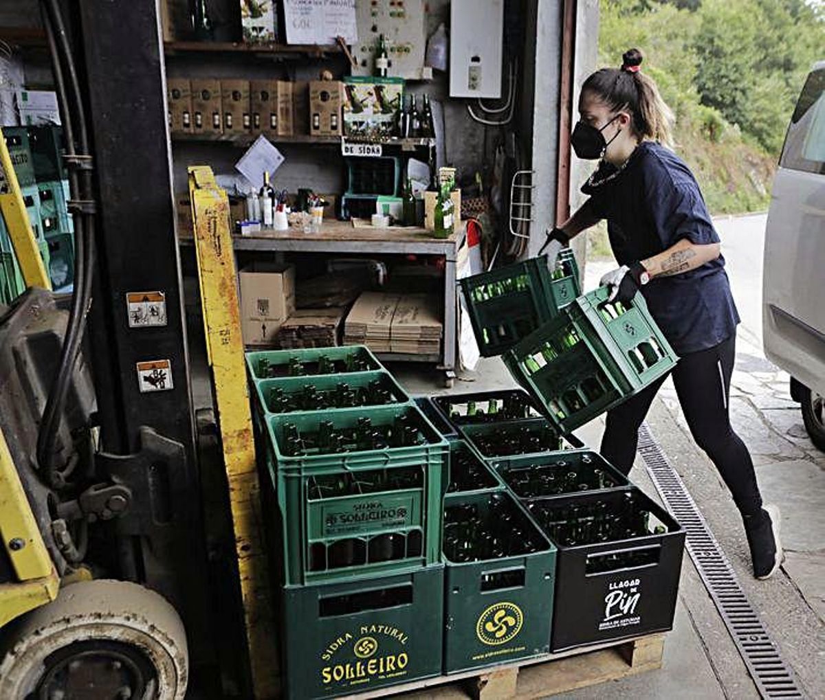 Arriba, a la izquierda, María Lorido colocando cajas de sidra en el Llagar de Pin. A la derecha, Pilar Quintana, en su telar. Junto a estas líneas, dos turistas paseando por Taramundi. Abajo, a la izquierda, Marcos Cerdeira tallando el mango de una navaja. Y, al lado, macetas en forma de muñeco, decorando una casa. | Fernando Rodríguez