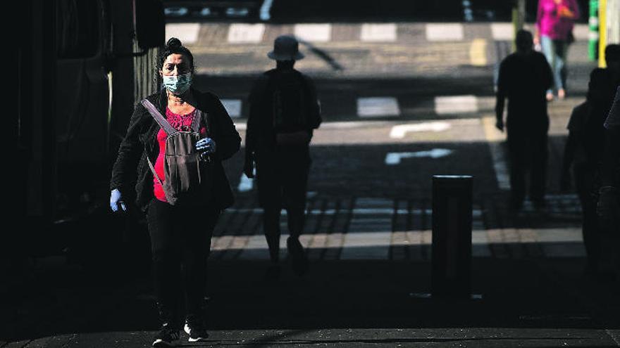 Varios peatones se desplazan por una céntrica calle de la capital tinerfeña en las primeras horas de la mañana.