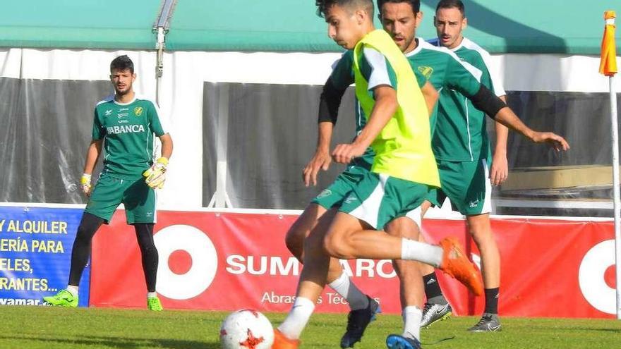 Pibe conduce el balón ante Mateo, durante el entrenamiento de ayer del Coruxo en O Vao. // J. A. D.