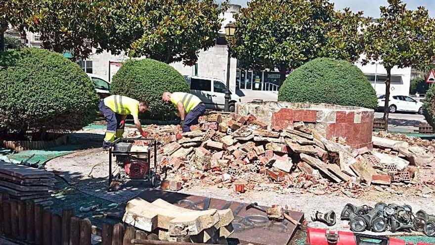 Obreros derriban la fuente de la plaza de Moreda. | Camporro