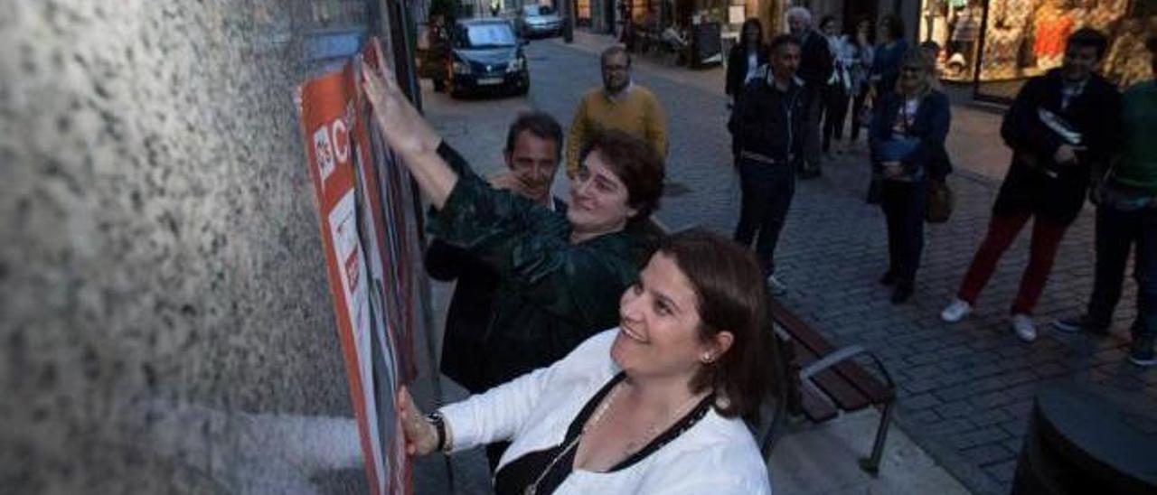 Los concejales Juan Cuesta y Carmen Pérez Soberón, con Sonia Arbesuk (en primer término, de blanco y negro), coordinadora de Ciudadanos en Avilés, durante la pegada de carteles en el inicio de la campaña para las últimas elecciones municipales, en mayo del año pasado.