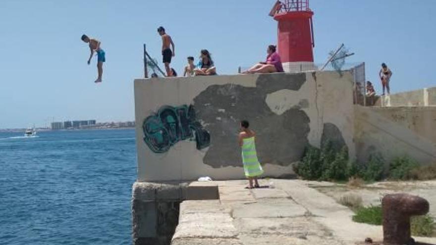 Imagen de los saltos en el faro del dique de Poniente del puerto de Torrevieja.