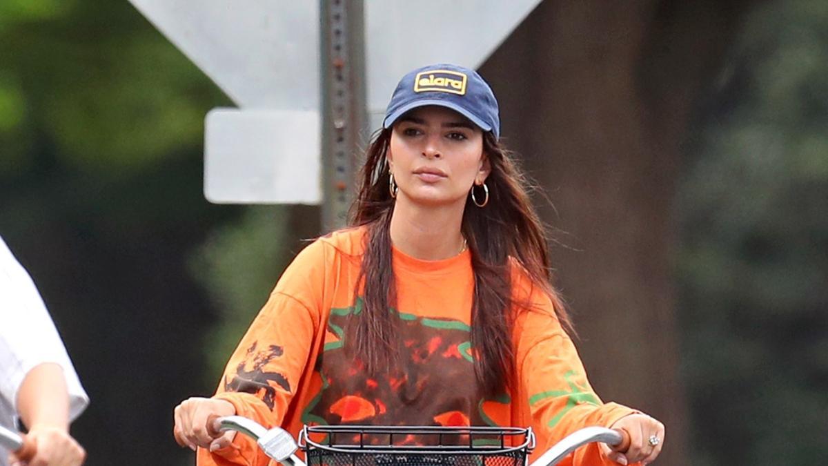 Emily Ratajkowski con zapatilla y camiseta larga paseando en bicicleta