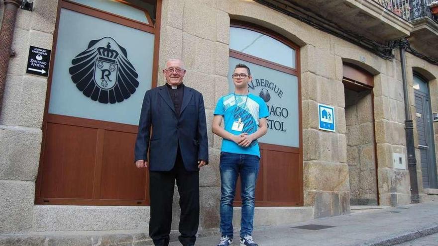 El párroco Benito Estévez y el encargado Yeray Rodríguez, ayer, en la puerta del albergue. A la izquierda, unos peregrinos descansan en las camas. // Faro