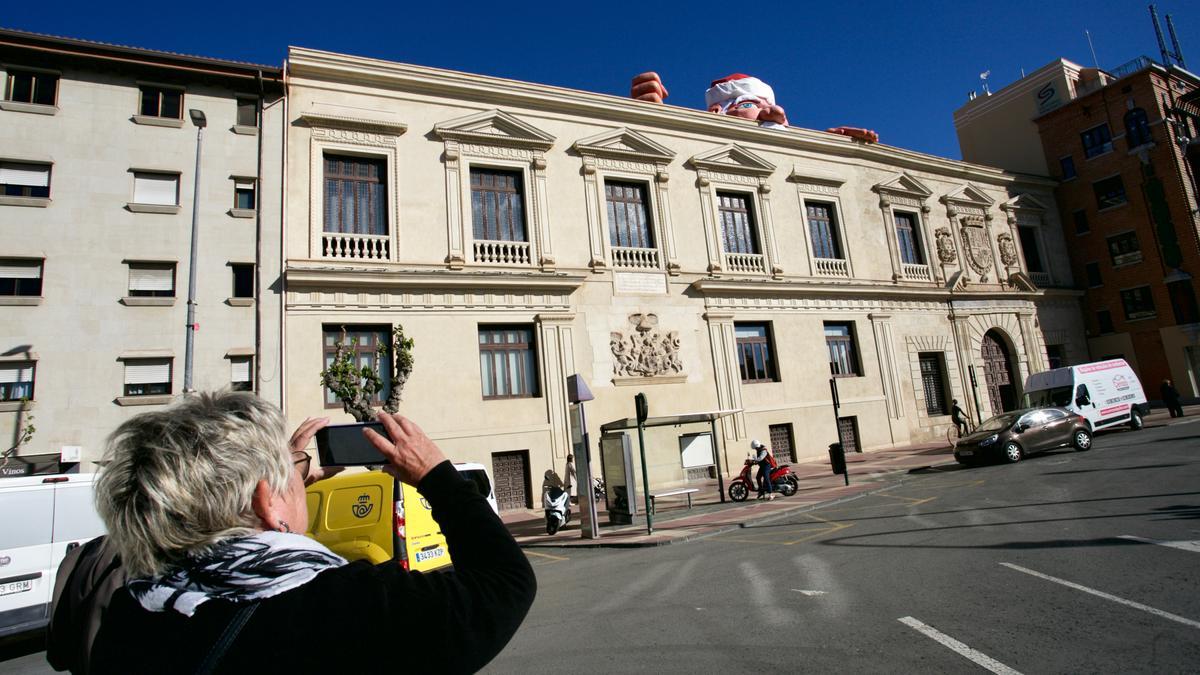 Una mujer hace una foto al Papá Noel del Palacio del Almudí