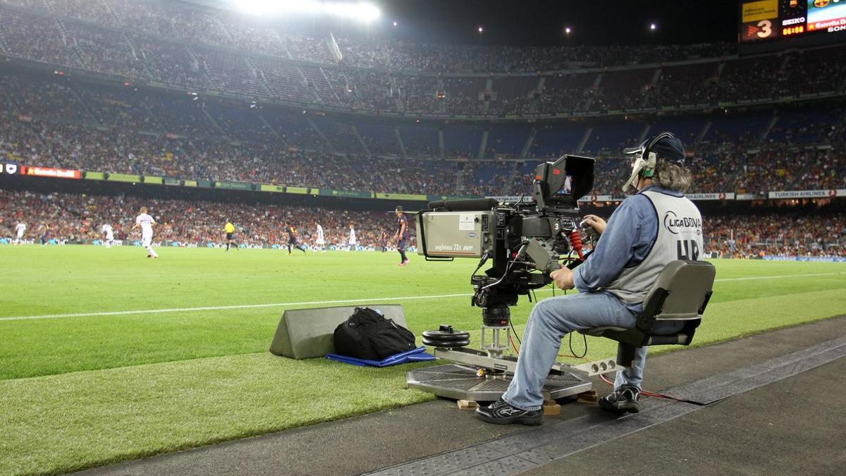 Un reportero gráfico grabando un partido de fútbol
