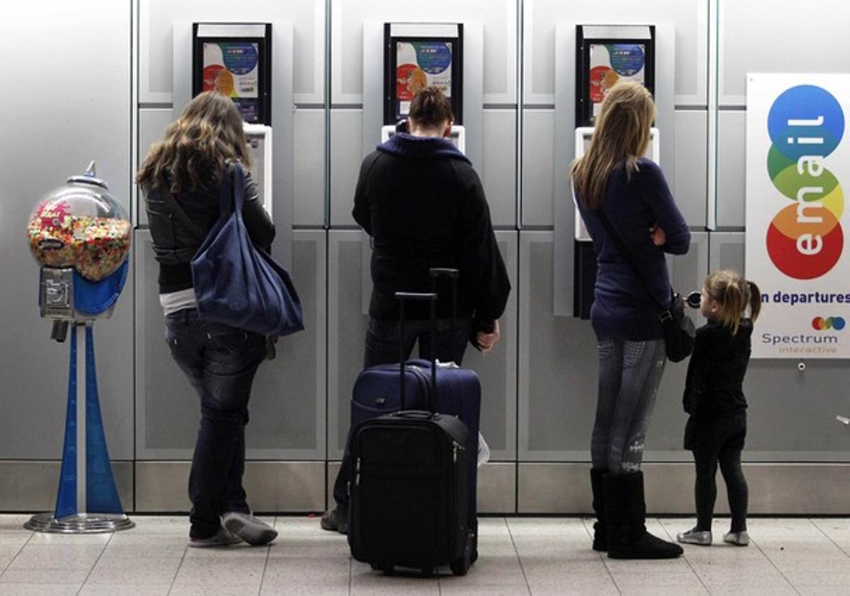 Caos aéreo. Tres mujeres hablan por teléfono con sus familiares para informarles de la cancelación de vuelos.