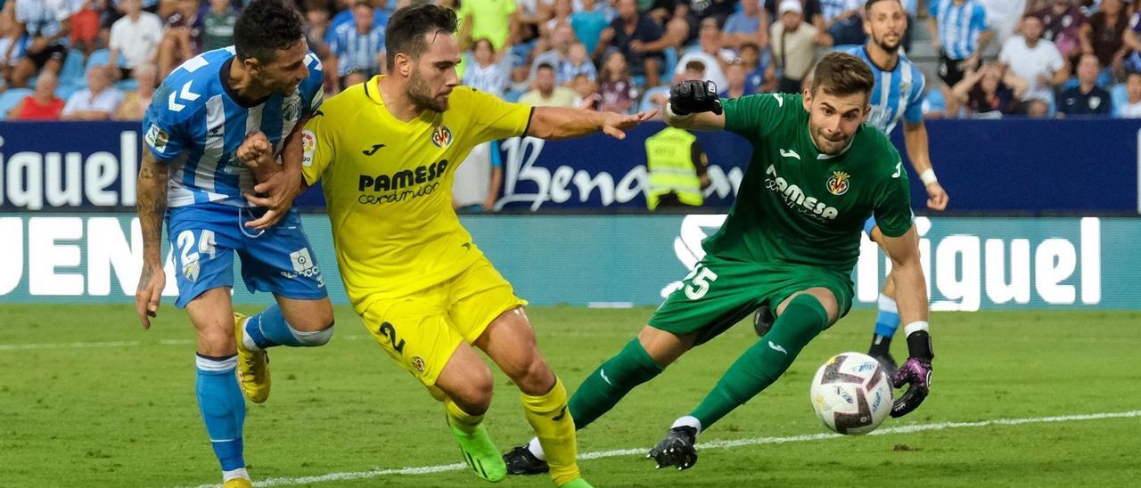 Rubén Castro remata a portería, ante la atenta mirada de Migue Leal y del portero Gianni Cassaró en el partido de ayer frente al Málaga en La Rosaleda.