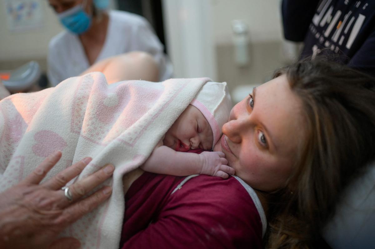 Aleina abraza a Snizhana, su hija, tras dar a luz en el hospital de Mikolaiv.