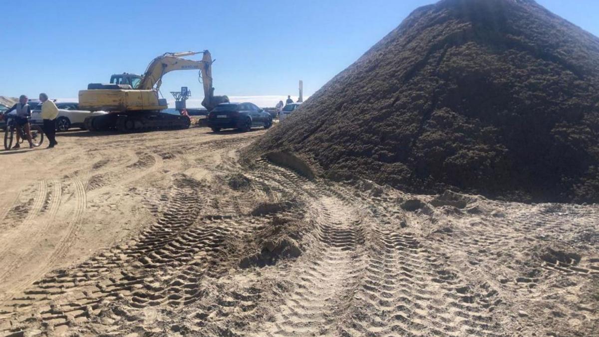 Maquinaria pesada a poca distancia de uno de los montículos de arena acumulada en la playa El Cable.