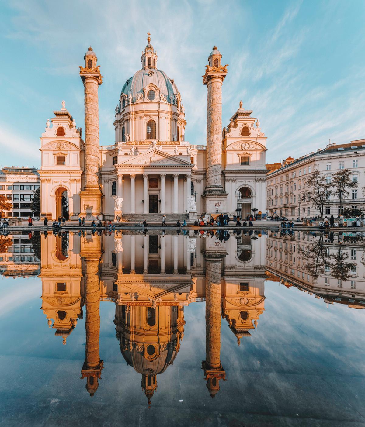 Luz del atardecer en la iglesia de San Carlos Karlskirche con reflexión en Viena, Austria
