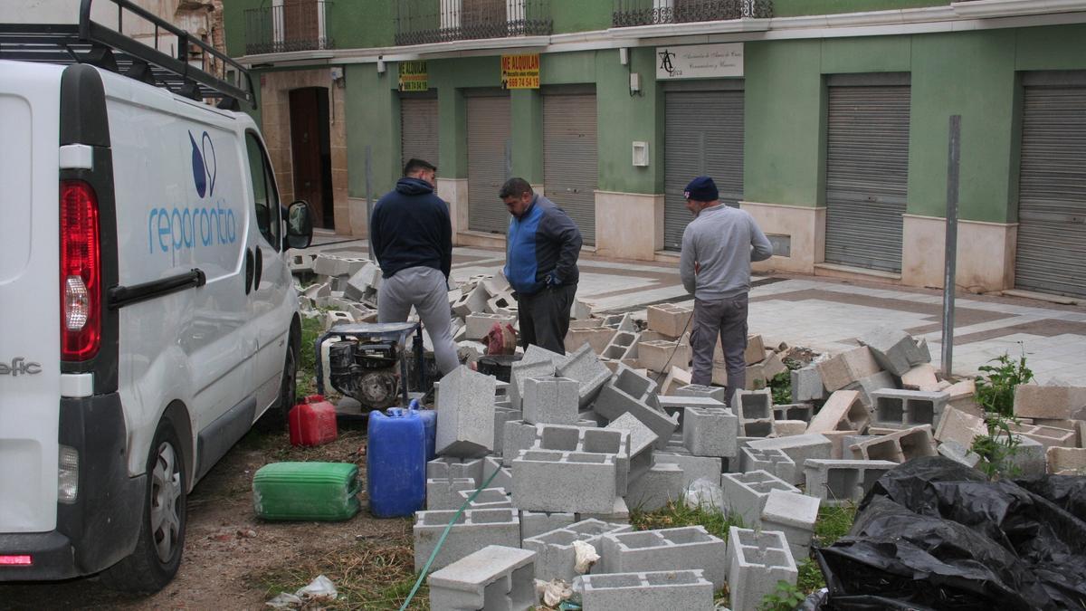 Operarios en el solar de la calle Zorrilla levantando la valla.