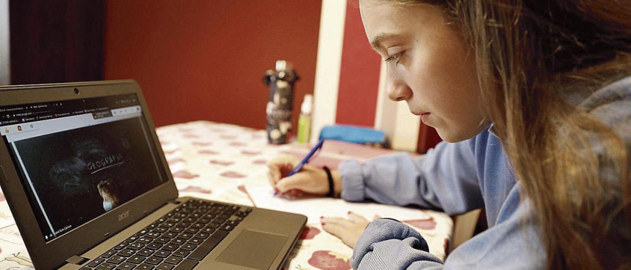 Celia López Riopedre, ayer, en su casa de Avilés, durante una clase de Geografía que impartió su tutora, Isabel Solís, que aparece en la pantalla del portátil.