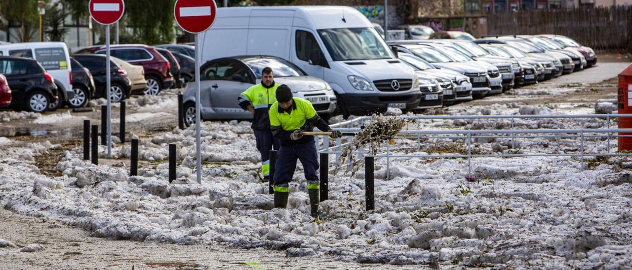 Operarios del servicio de limpieza retiran restos de todo lo arrastrado por la tormenta entre restos de hielo en Alicante. | RAFA ARJONES