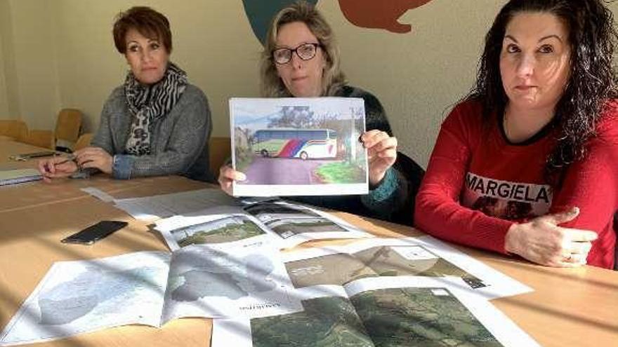 Marta Rodríguez, Beatriz Rodríguez, mostrando una fotografía de un autobús dando la vuelta en el pueblo, y María Teresa Mallada.