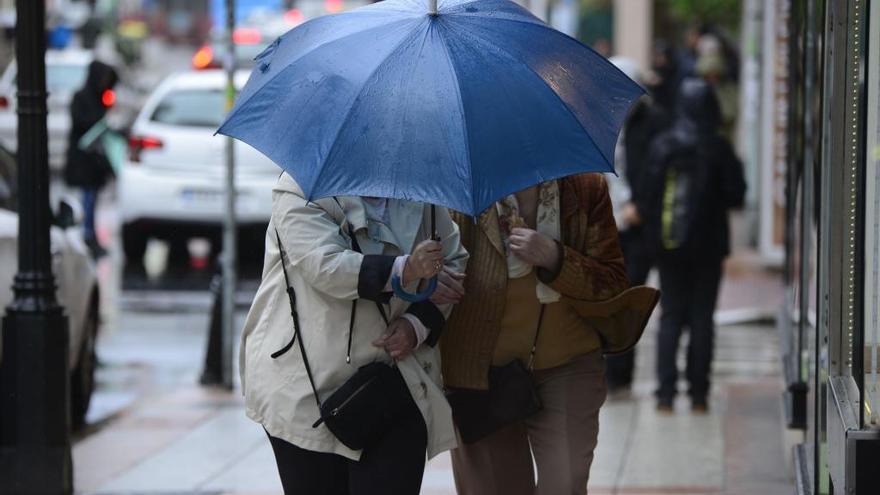 Dos mujeres se protegen de la lluvia. // Roller Agencia