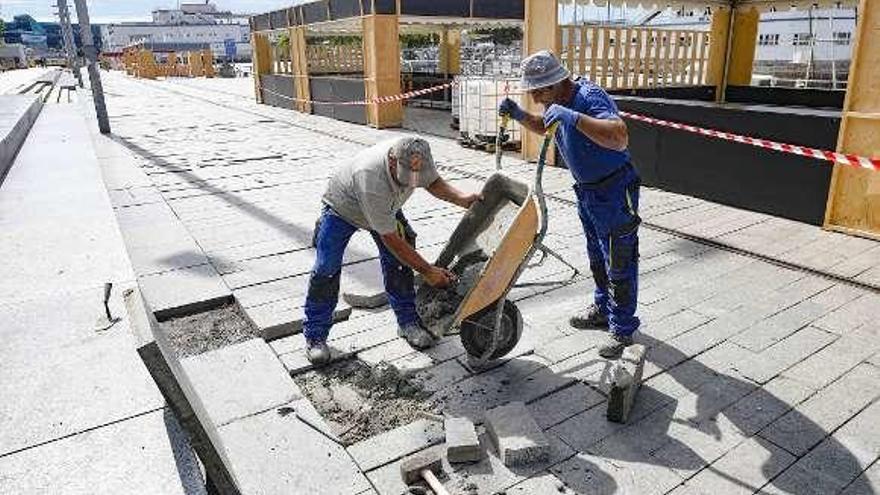 Obreros reparan las losetas de As Avenidas para el SeaFest. // R.G.