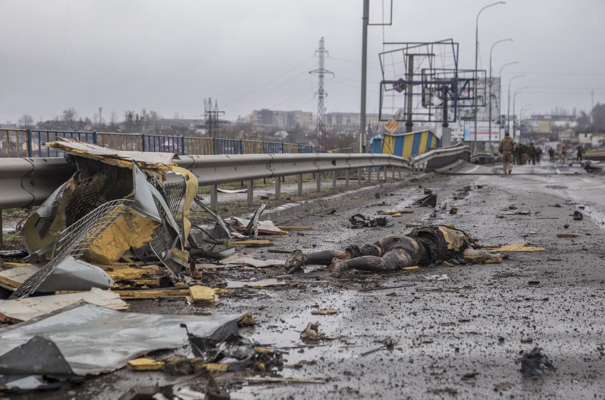 El cuerpo sin vida de un hombre en la carretera de la localidad de Bucha.