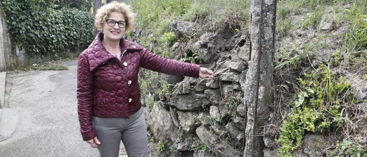 Maribel Vázquez, vecina del barrio, ante el muro municipal frente a su casa que amenaza desplome. // S.A.