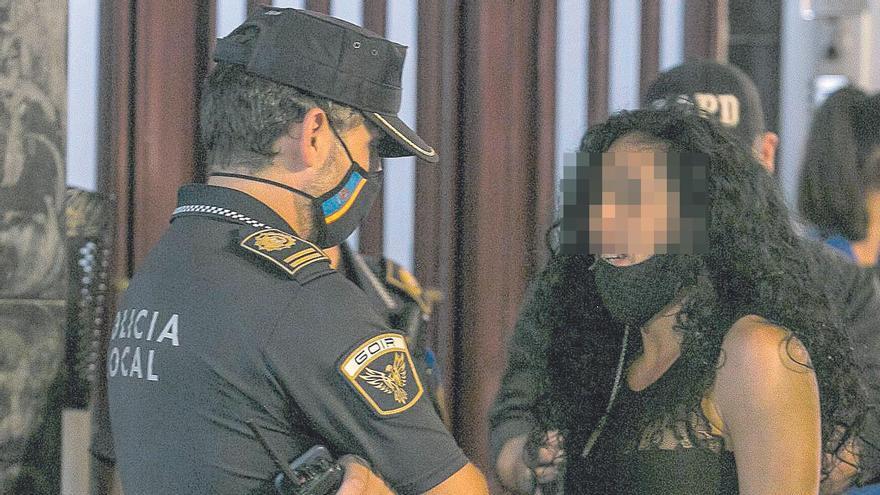 Una mujer discute con un agente de la Policía Local con la mascarilla bajada tras pedirle la documentación por fumar sin respetar la distancia mínima establecida.