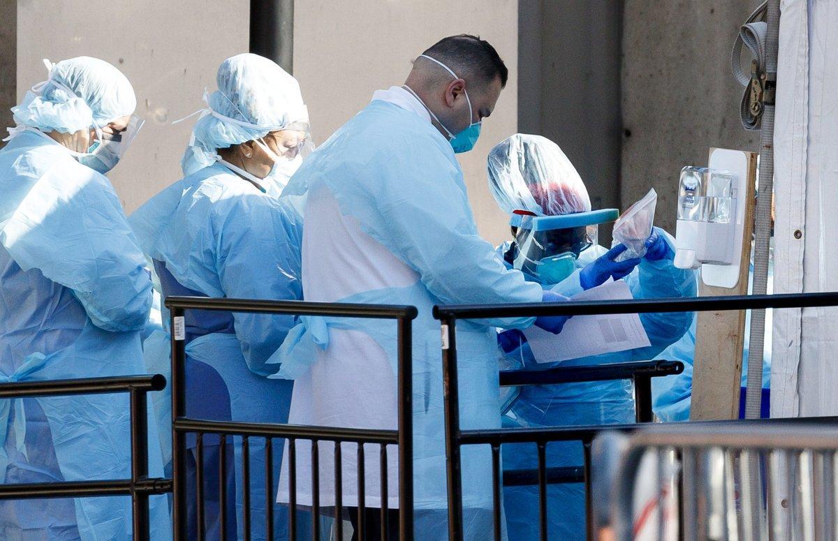 New York (United States), 26/03/2020.- Medical professionals work at a coronavirus testing tent set up at the Brooklyn Hospital Center in Brooklyn, New York, USA, 26 March 2020. A statewide shut down of all non-essential businesses and a ban on all non-solitary outside activities is currently in place to stop the spread of coronavirus and COVID-19. City and state officials around the city, and the country, are hoping these measures will help to avoid overwhelming hospital systems that are already straining with the volume of patients during intensive care. (Estados Unidos, Nueva York) EFE/EPA/JUSTIN LANE