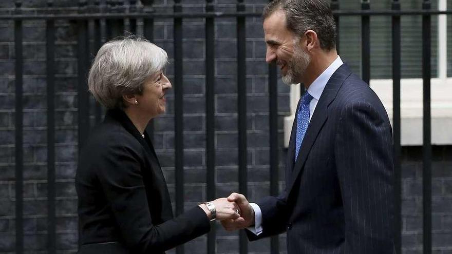 La primera ministra británica, Theresa May, saluda a Felipe VI a la puerta de su residencia oficial. // Efe