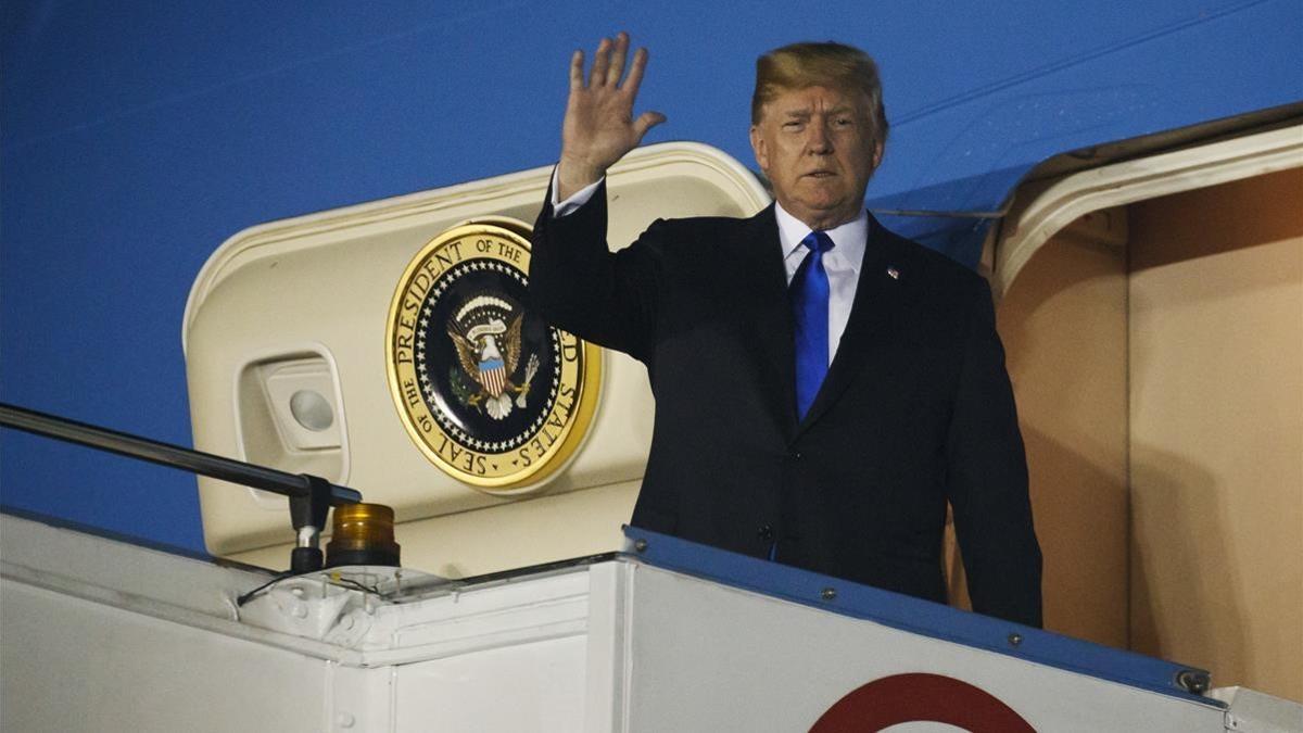 Trump saluda desde al 'Air Force One' a su llegada a Singapur.