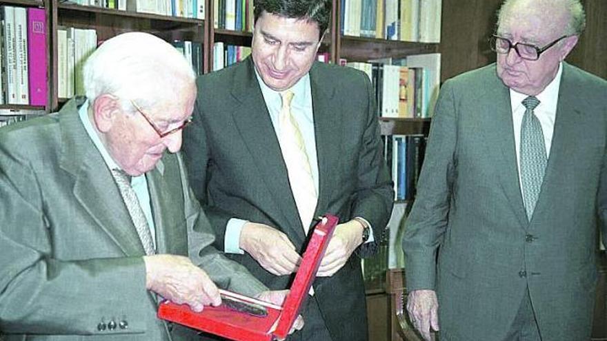 El jurista Rodrigo Uría recibe la medalla de oro de la Universidad Internacional Menéndez Pelayo, en noviembre de 2000, en presencia de José Luis García Delgado y de Aurelio Menéndez.