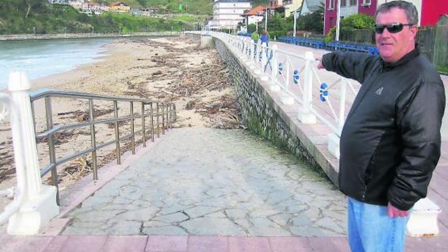 El riosellano Fernando Barro indica el lugar de la playa donde aún abundan troncos y basura.