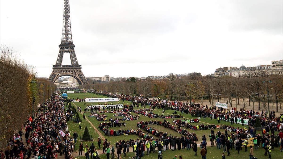 TO GO WITH AFP PACKAGE   Fifth anniversary of Paris Agreement on climate change -(FILES) In this file photo taken on December 12  2015 Several Non Governmental Organisations (NGO) gather to form a human chain  reading   3 C SOS  on the Champs de Mars near the Eiffel Tower in Paris on the sidelines of the COP21  the UN conference on global warming  (Photo by ALAIN JOCARD   AFP)