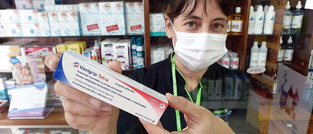 Una boticaria muestra una dosis de vacuna de la gripe en la Farmacia Viéitez López