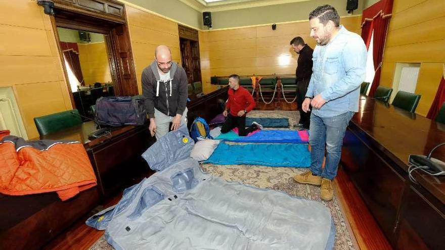 Los trabajadores despliegan unos colchones hinchables en el salón de plenos.