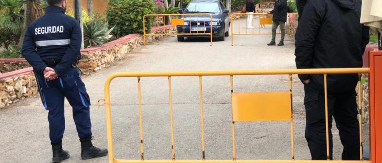 Los vigilantes del control de acceso esperan la salida del coche de una pareja de okupas que ayer abandonaba las instalaciones. | J.A.C