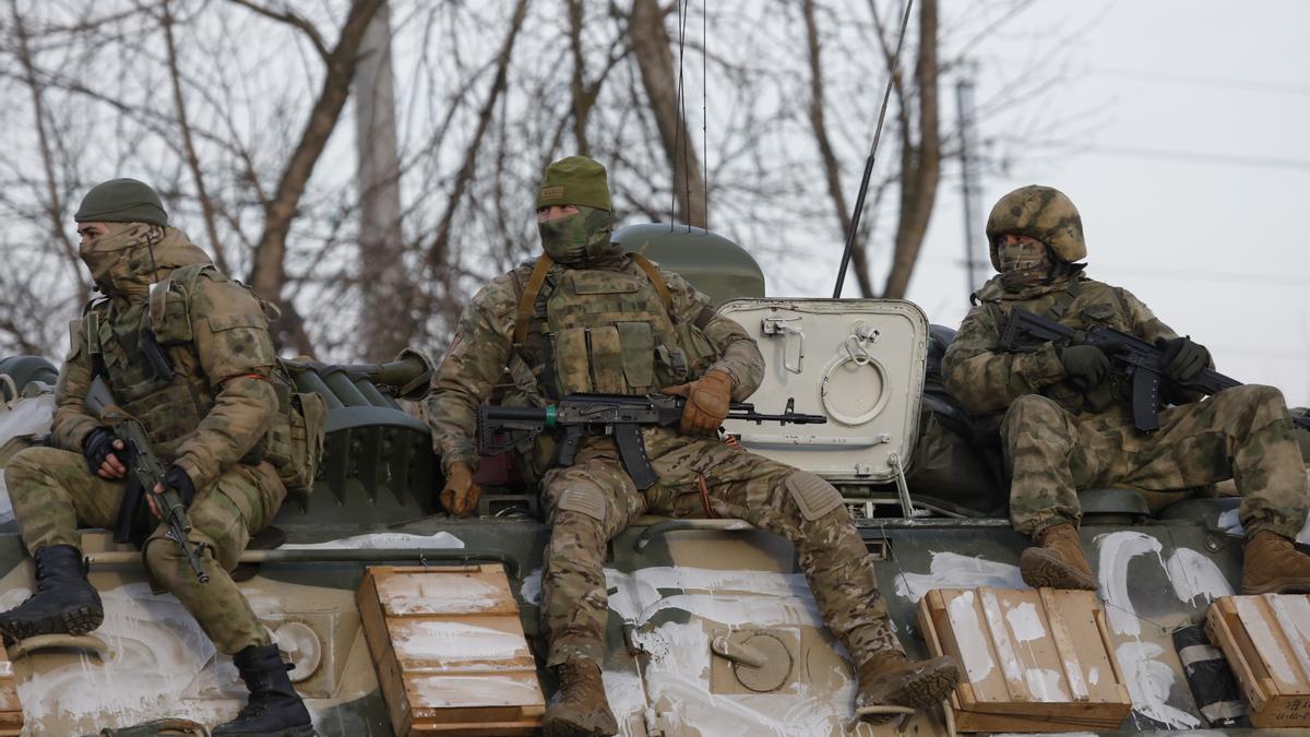 arios militares viajan en un vehículo blindado por una carretera cerca de la frontera entre Rusia y Ucrania.