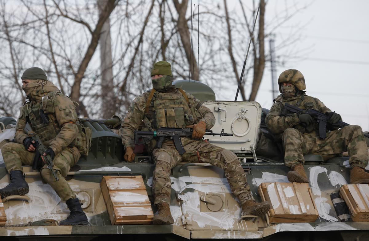 arios militares viajan en un vehículo blindado por una carretera cerca de la frontera entre Rusia y Ucrania.