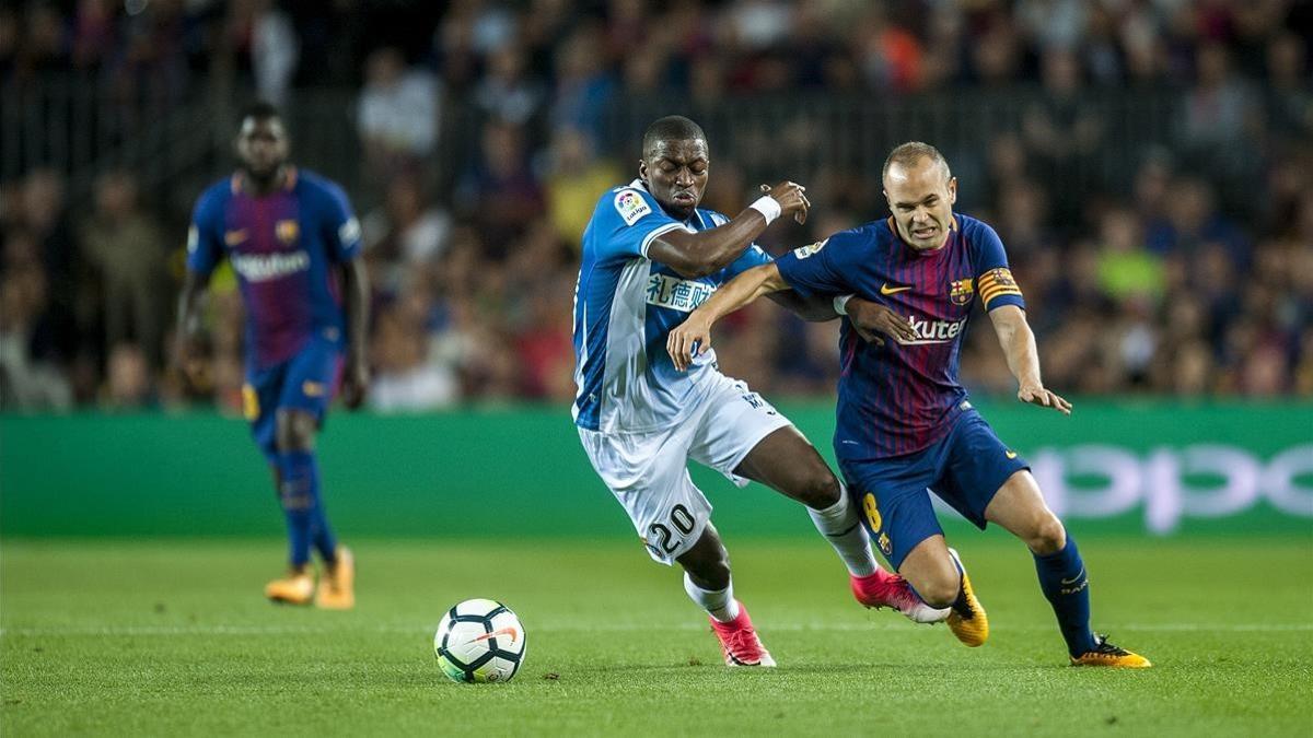 Diop e Iniesta pugnan por el balón en el Camp Nou.