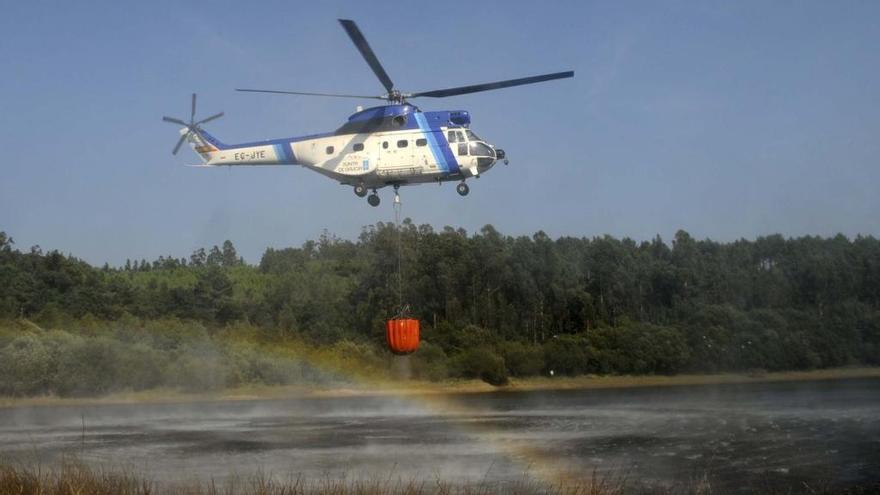 Un helicóptero carga agua para luchar contra el fuego en Galicia // Noé Parga