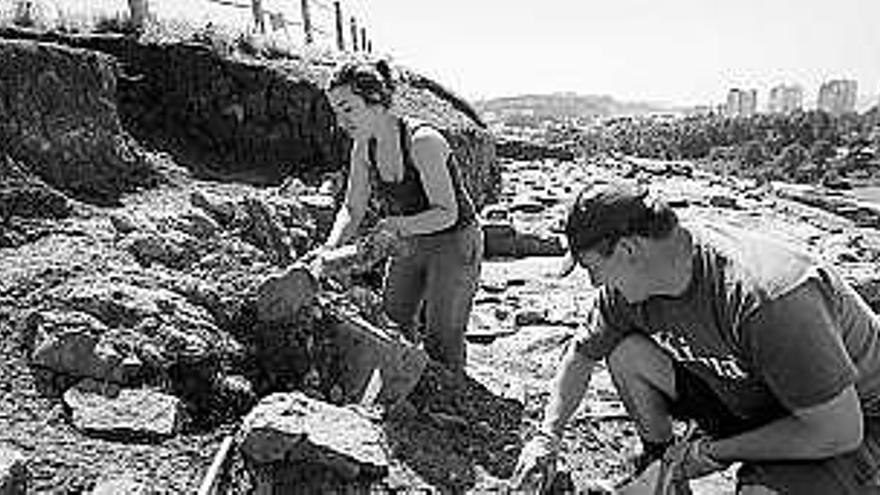 Dos miembros del equipo de arqueólogos, trabajando en el yacimiento.