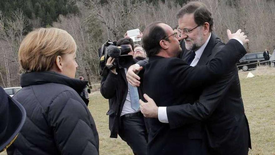 Rajoy y Hollande se abrazan en presencia de Angela Merkel, ayer en Seyne-les Alpes. // /Christophe Ena/Efe
