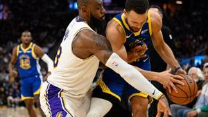 LeBron trata de detener a Curry.