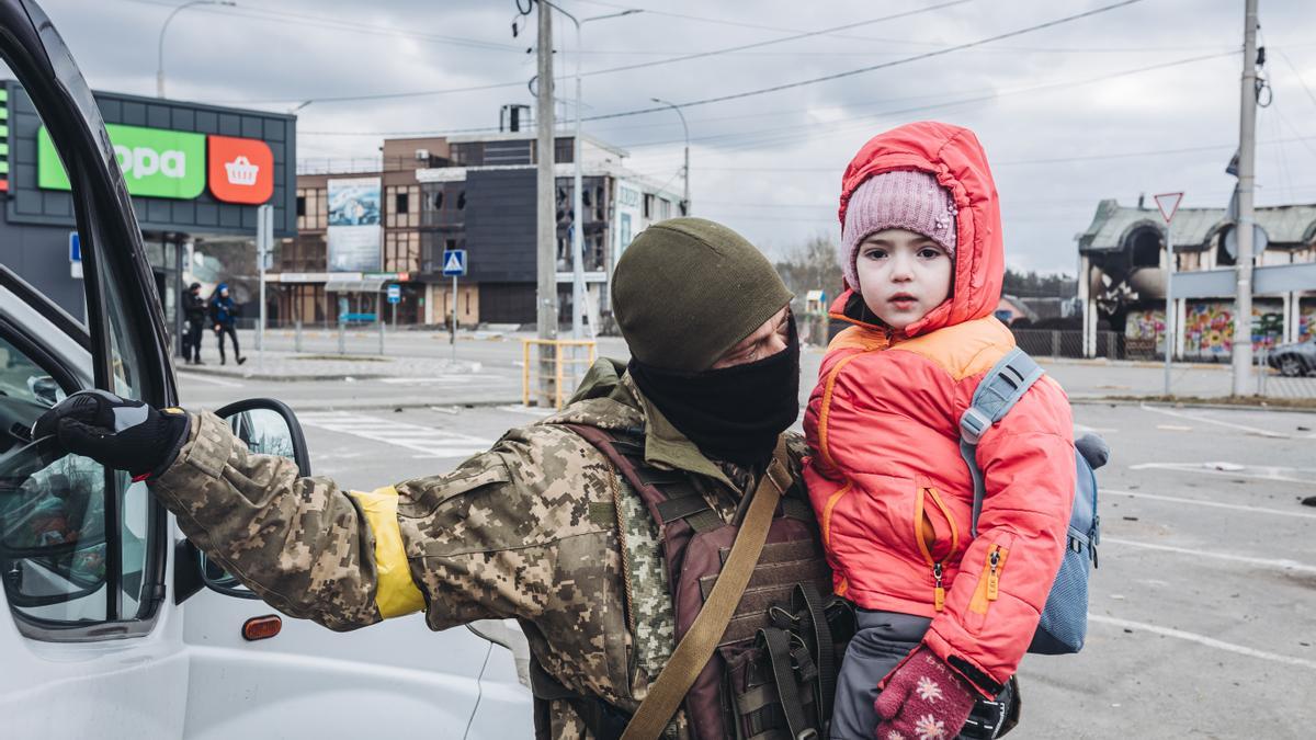 Un soldado ayuda en la evacuación de un niño en Irpin.