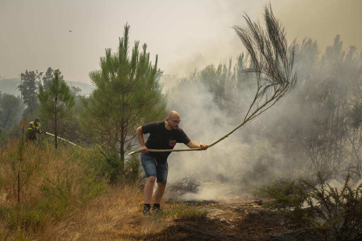 Un vecino de Vilar de Condes colabora en las labores de extinción del incendio forestal en Carballeda de Avia (Ourense), este sábado