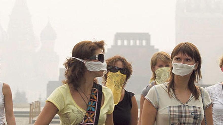 Un grupo de turistas se protege con mascarillas del humo en la plaza Roja de Moscú.