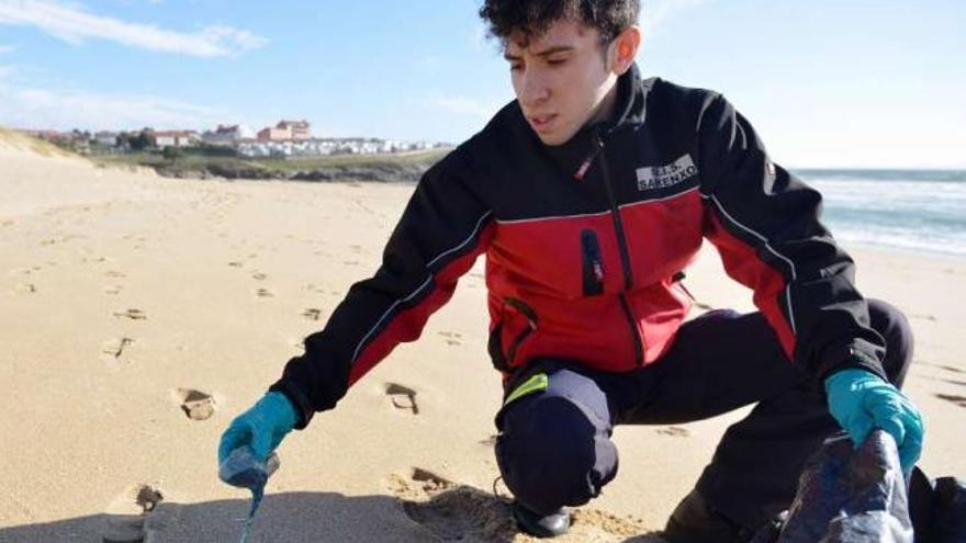 Un miembro del Servizo de Emerxencias de Sanxenxo retira una de las carabelas portuguesas.  // G. S.