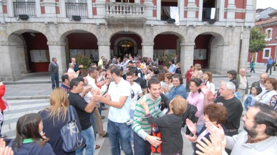 Una aficionado abraza a Gayol a la salida del Consistorio con sus compañeros a su espalda.