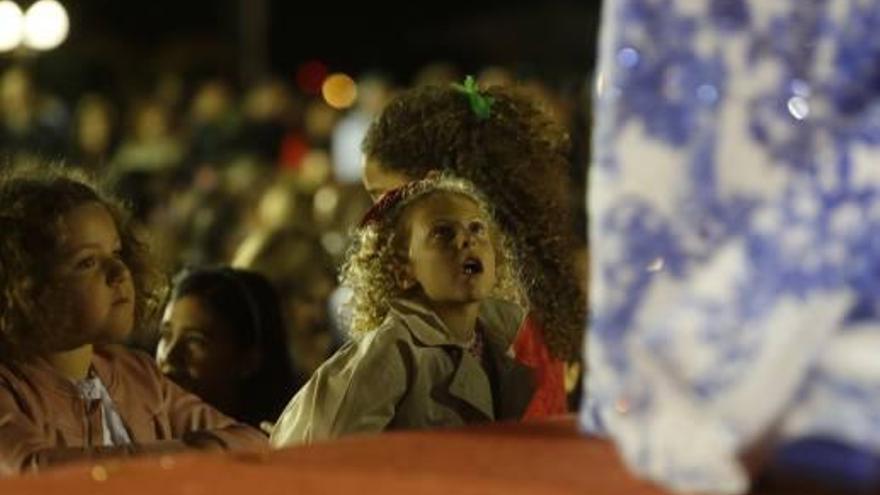 Miles de personas asistieron a la pasarela del puerto, y también muchos niños algunos de los cuales, como se aprecia en la imagen, muestran su sorpresa y su admiración al ver los trajes de las candidatas.