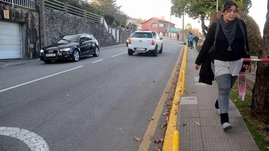 Una viandante por la calle Pernas Peña y varios turismos circulando en los dos sentidos. // Rafa Vázquez