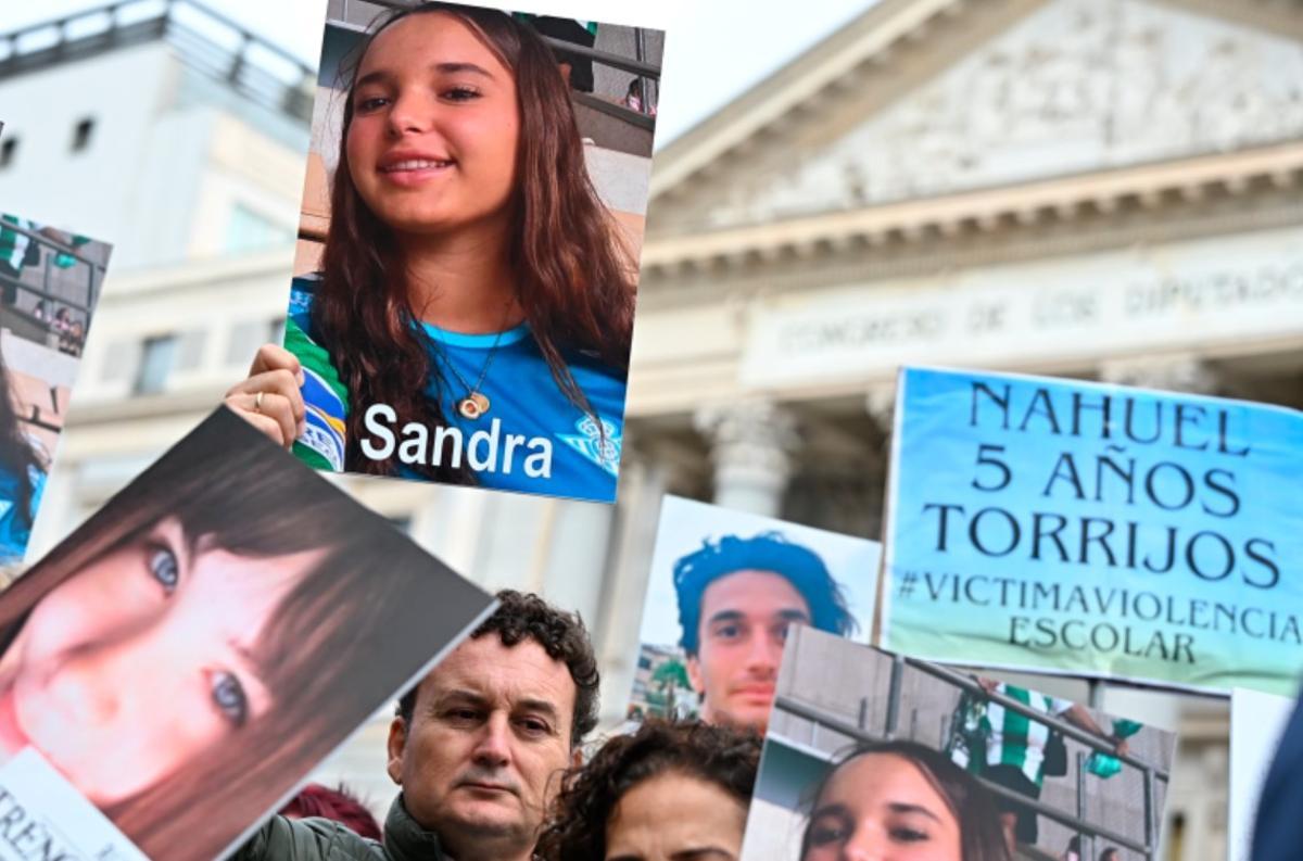 Familiares y amigos de v­íctimas de acoso, durante la manifestación frente al Congreso de los Diputados, esta mañana.