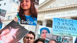 Familiares y amigos de v­íctimas de acoso, durante la manifestación frente al Congreso de los Diputados, esta mañana.